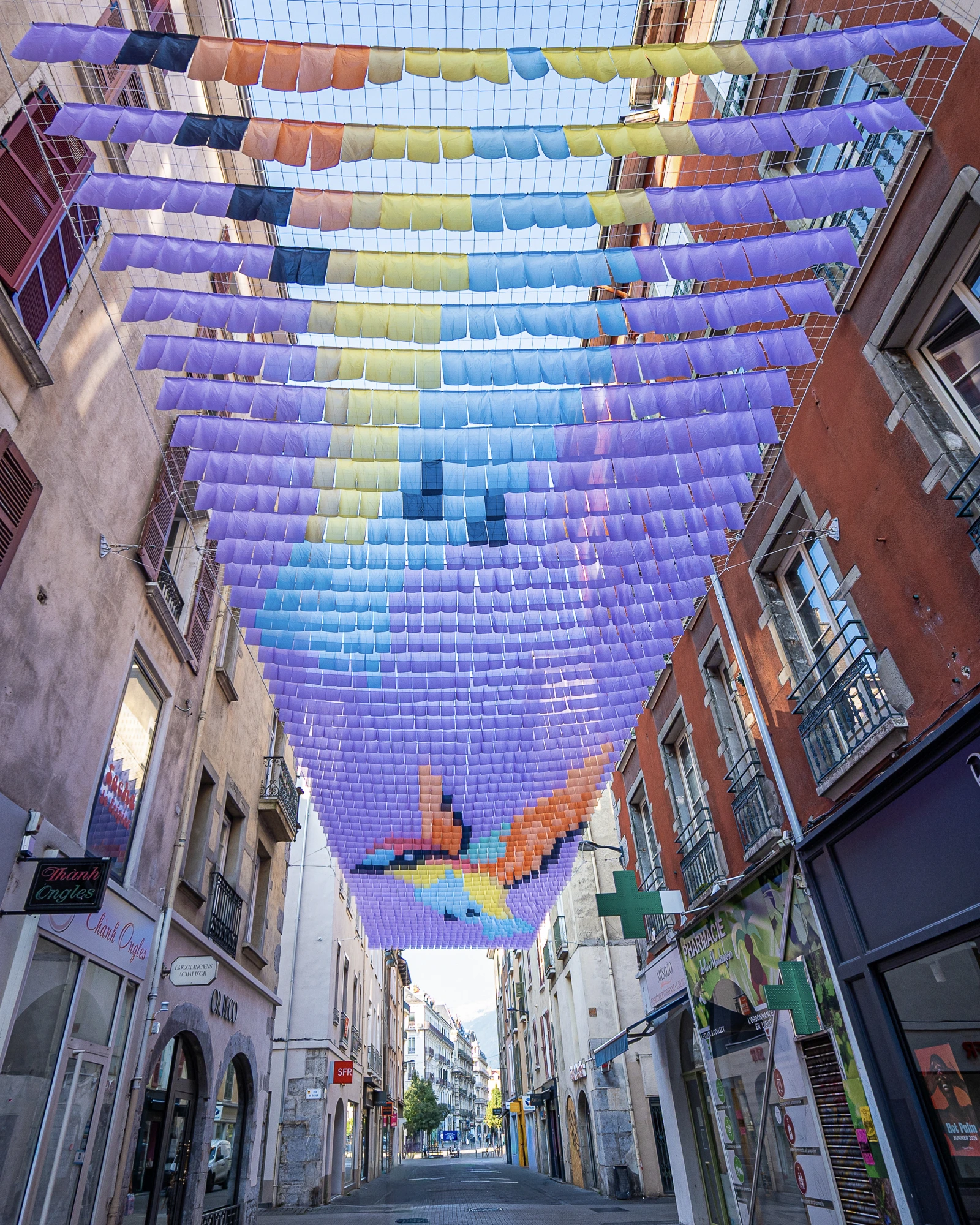 Grenoble 2026. Chassagnac Atelier. Ciel-de-rue. Ciel en drapeaux. Canopée chromatique. Ombre et art. Canopée textile. Installation artistique monumentale. Ombre canicule. Voile d'ombrage. Ciel d'ombrage.