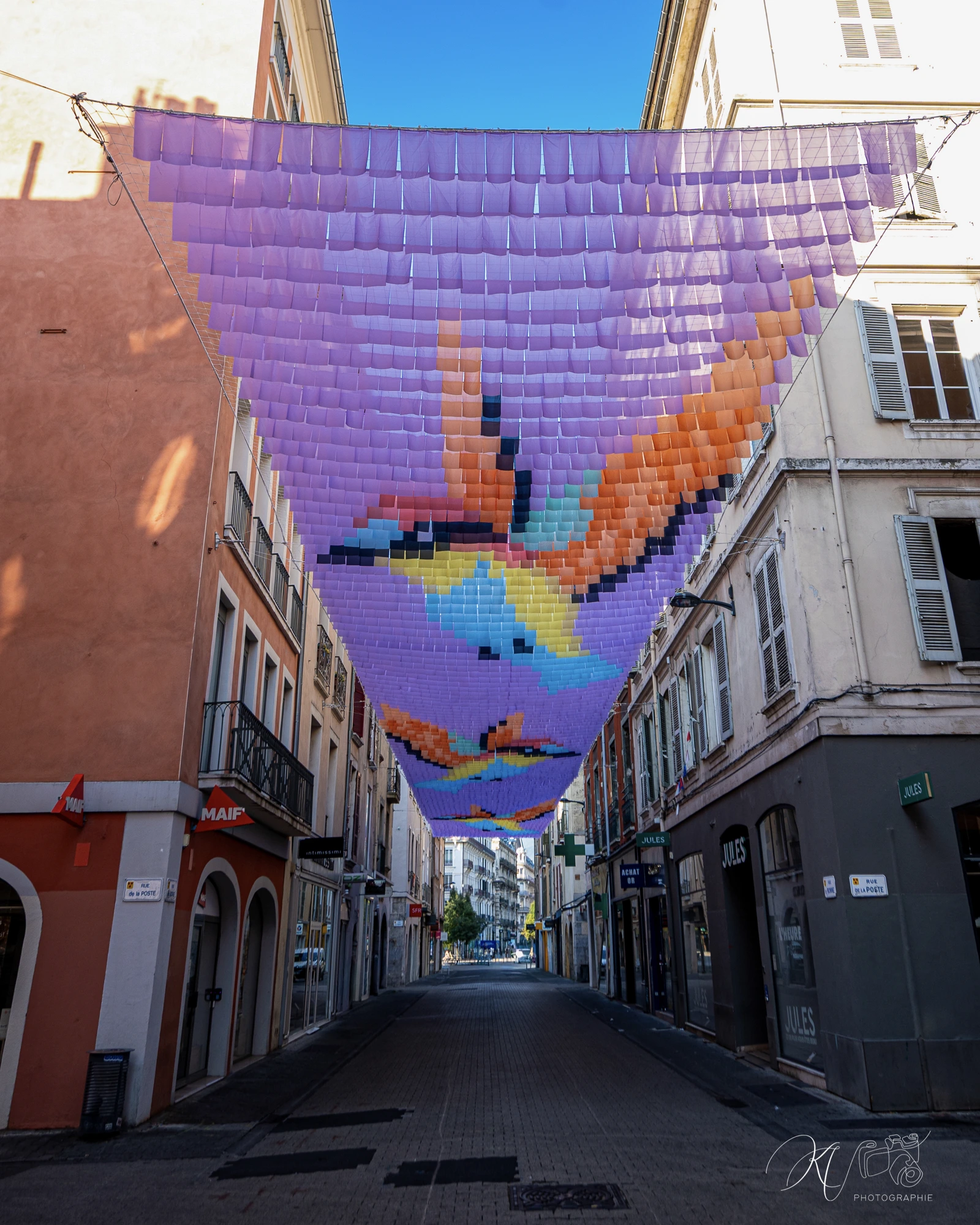 Grenoble 2026. Chassagnac Atelier. Ciel-de-rue. Ciel en drapeaux. Canopée chromatique. Ombre et art. Canopée textile. Installation artistique monumentale. Ombre canicule. Voile d'ombrage. Ciel d'ombrage.